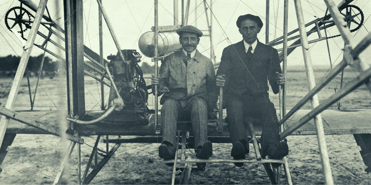 Wilbur and Orville Wright seated on the Wright Flyer