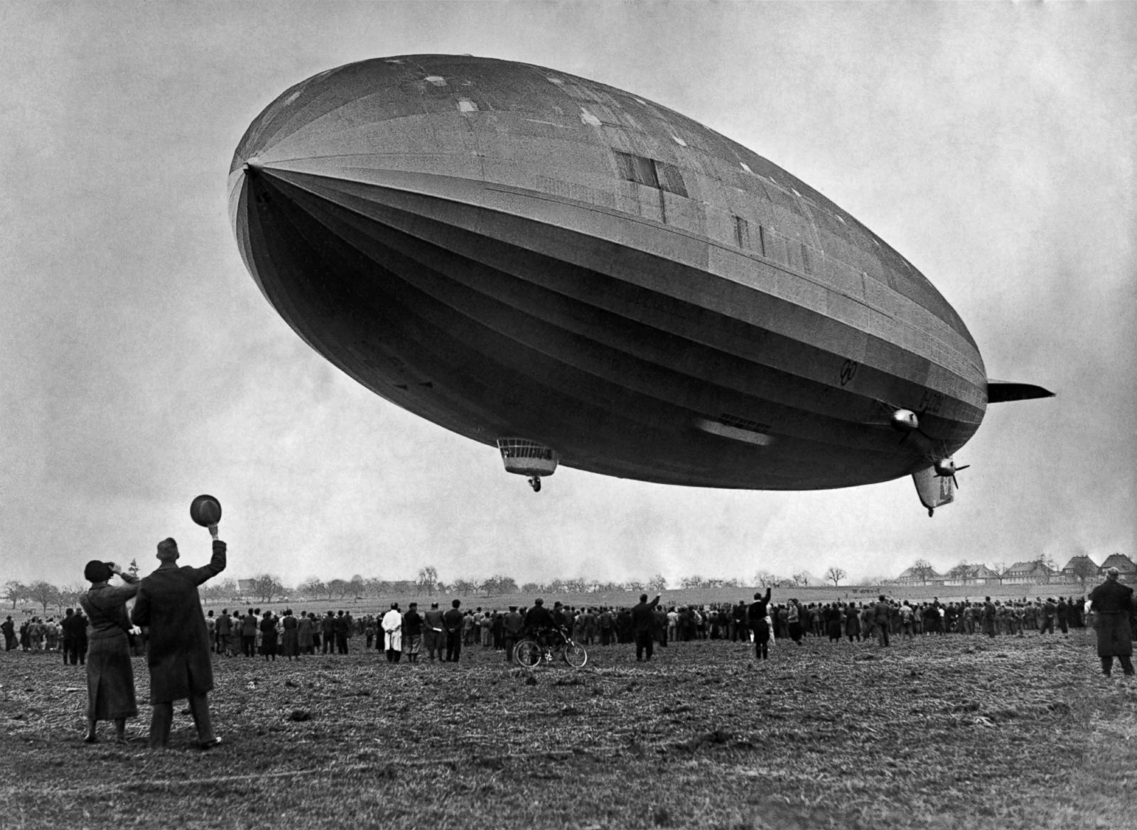 The Hindenburg airship in flight over a crowd of onlookers, circa 1936