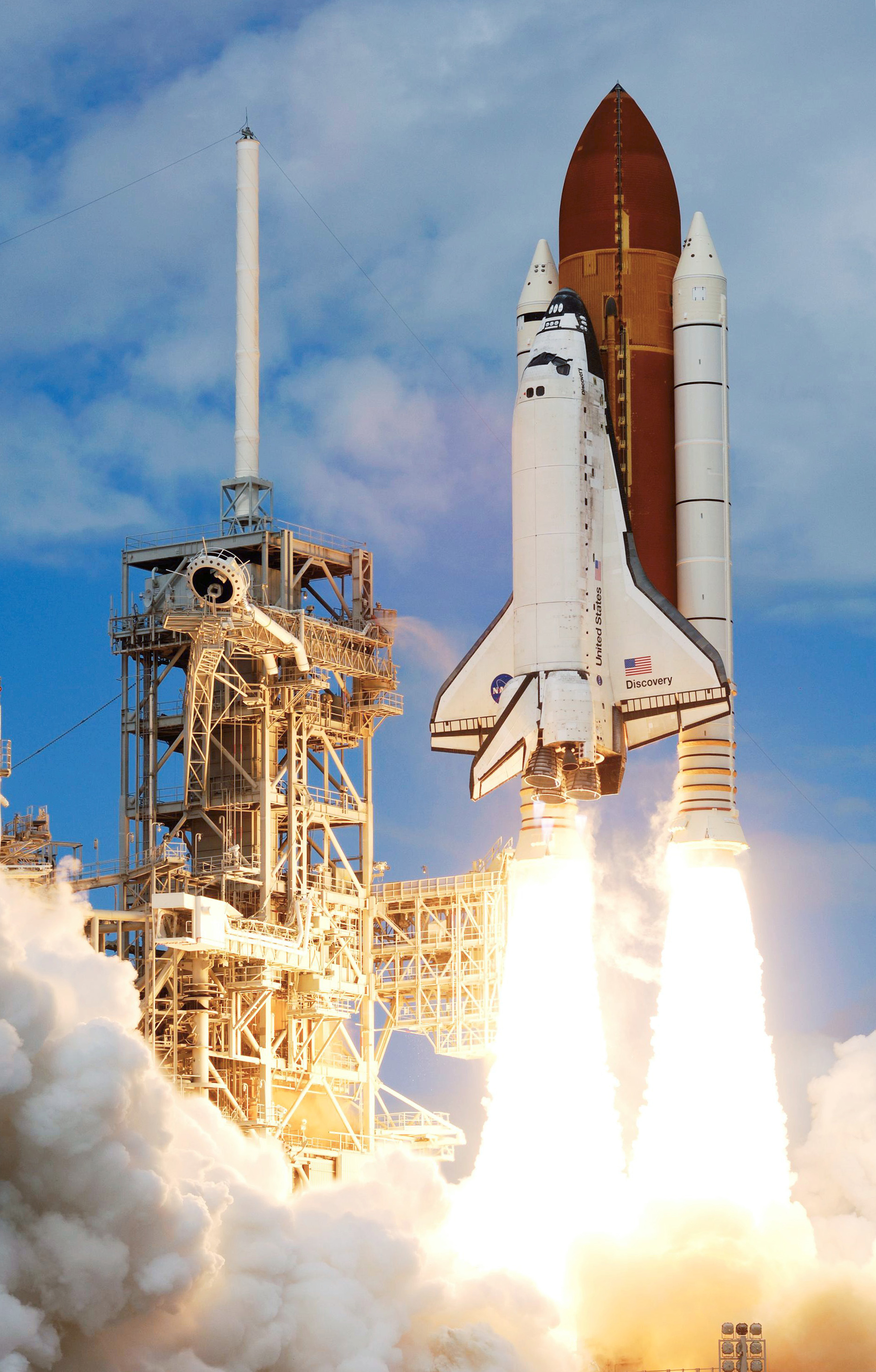Space Shuttle Discovery lifting off from the launch pad with billowing exhaust plumes